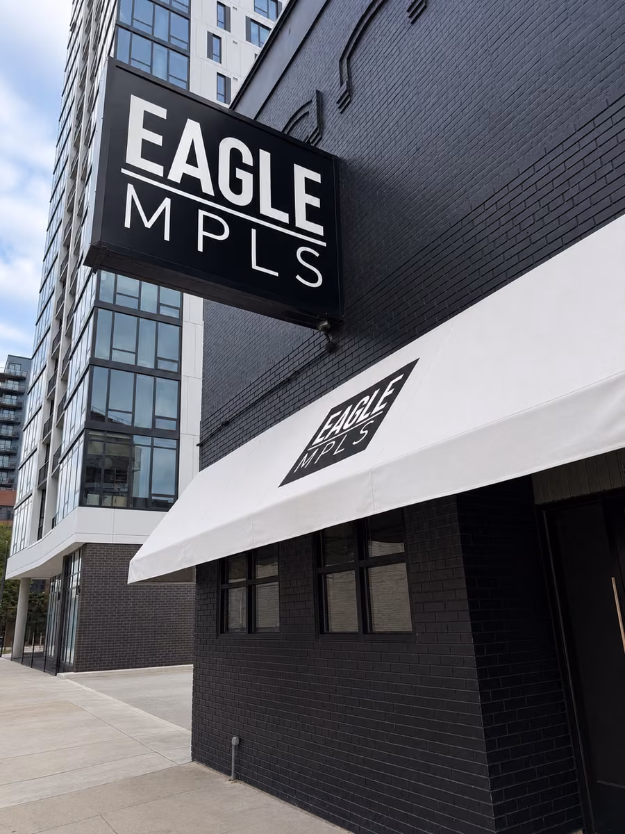 Black Eagle MPLS exterior with a vertical sign above a white entrance awning.